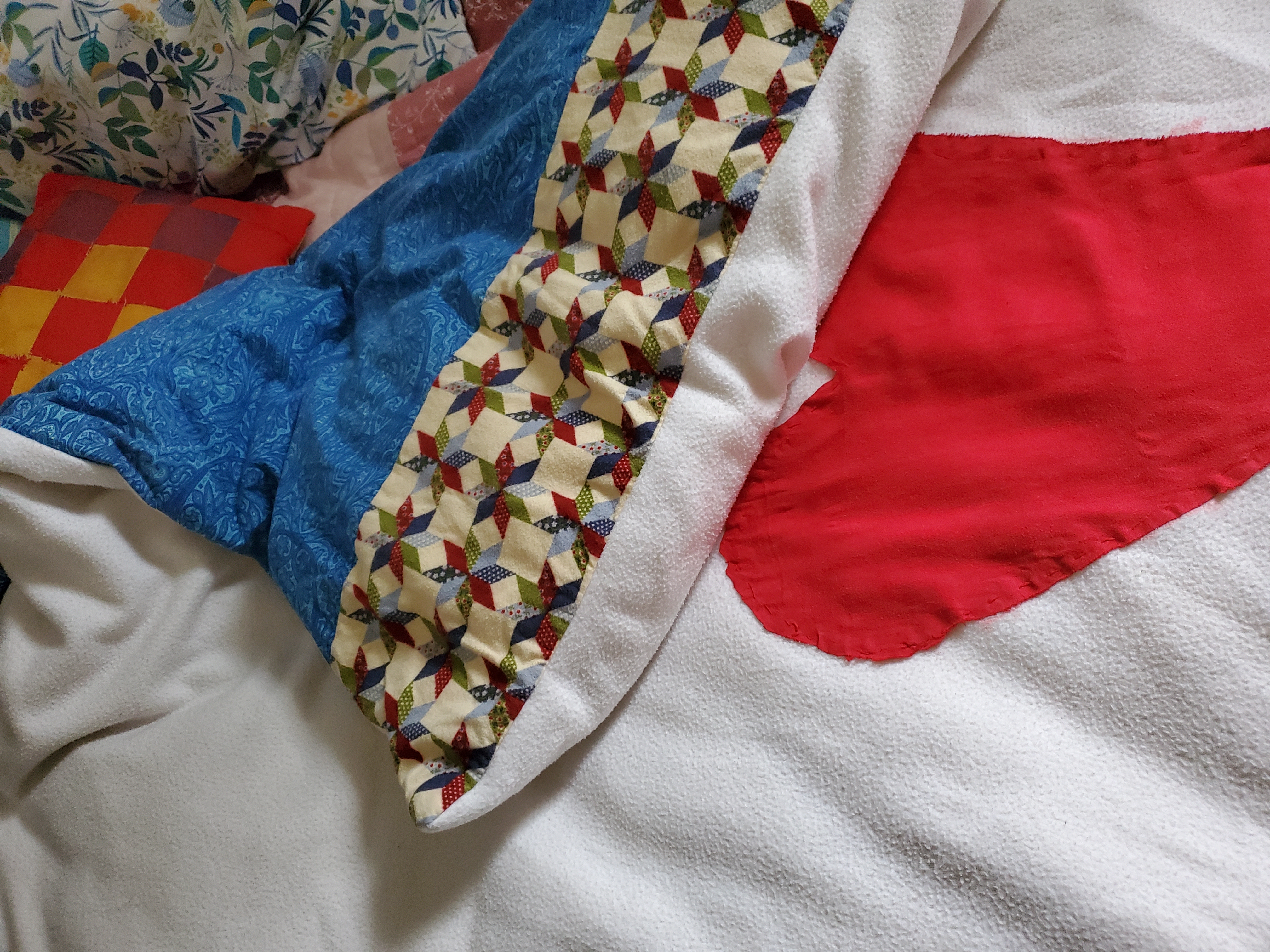 The cover on my bed with a homemade pillow in the background