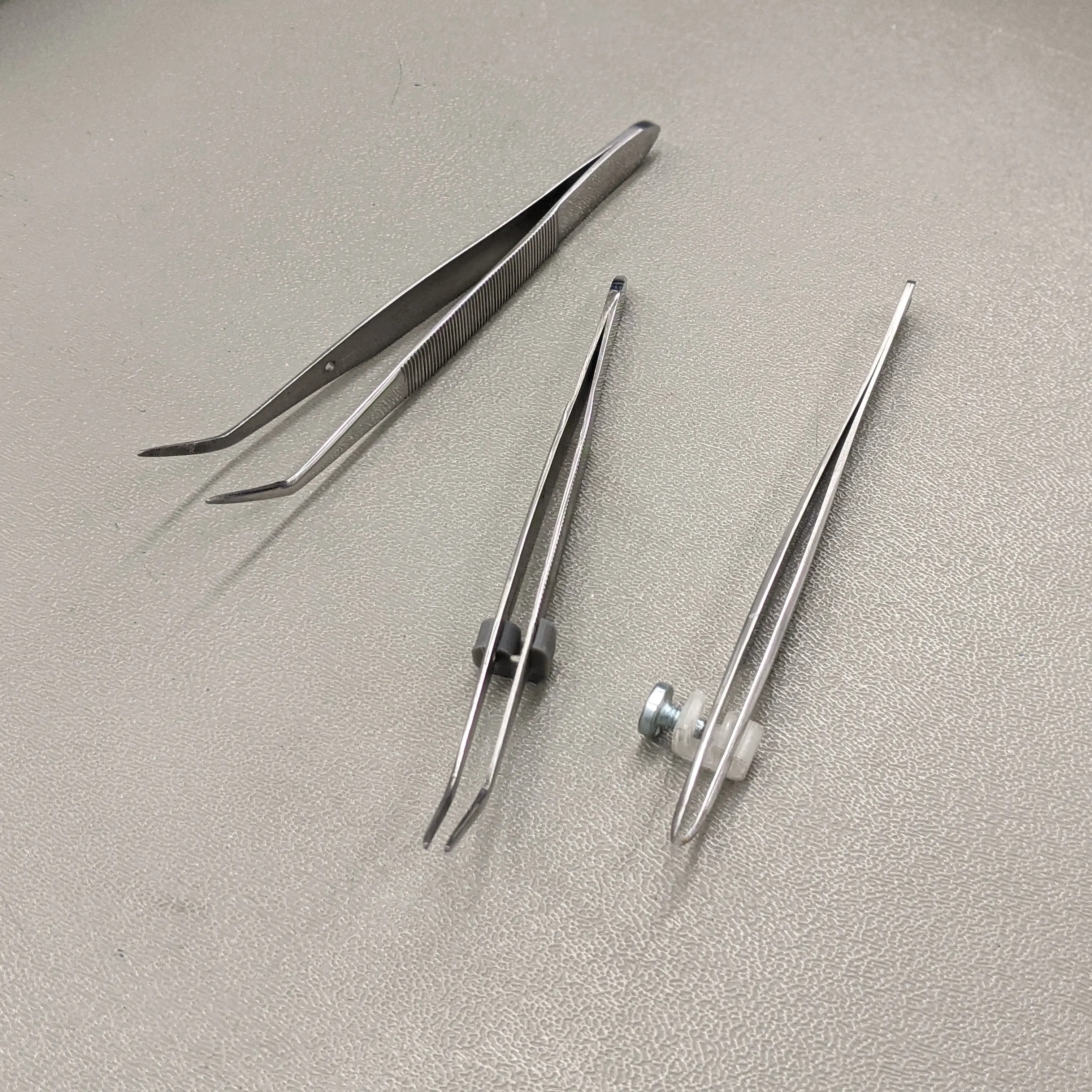 A collection of tweezers with the modification attached
